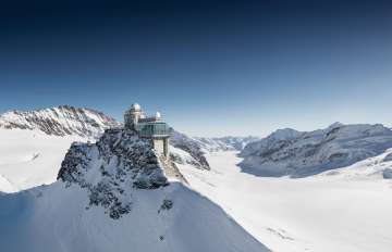 Luftaufnahme des Jungfraujoch im Winter. Im Hintergrund ist neben dem Bergpanorama der Aletschgletscher zu sehen.