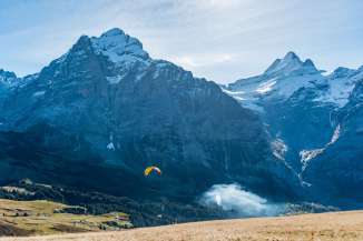 Der Start vor der eindrücklichen Bergkulisse ist geglückt: Tandempilot Christoph Mühlemann unterwegs mit einer Passagierin von Grindelwald-First nach Grindelwald.