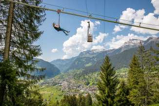 Pfingstegg Fly Line mit einer Person. Grindelwald und Gondelbahn im Hintergrund.