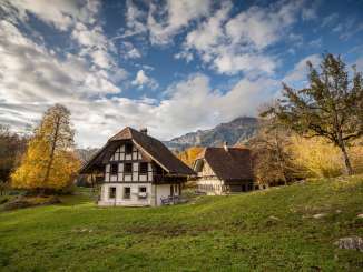 Die Häuser im Freilichtmuseum Ballenberg in ihrer ursprünglichen Bauweise stehen inmitten grüner Wiesen.
