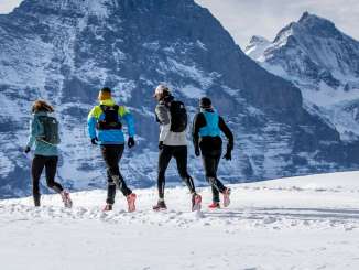 Zwei Läufer beim Winter Trail Running auf Grindelwald First, im Hintergrund der Eiger.